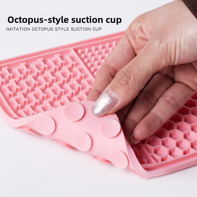 The dog licks the pet feeding pad on the table.