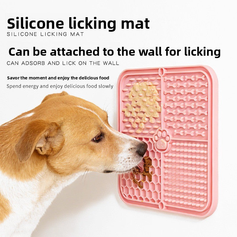 The dog licks the pet feeding pad on the table.