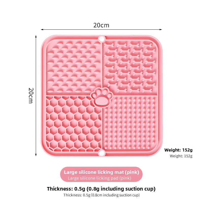 The dog licks the pet feeding pad on the table.